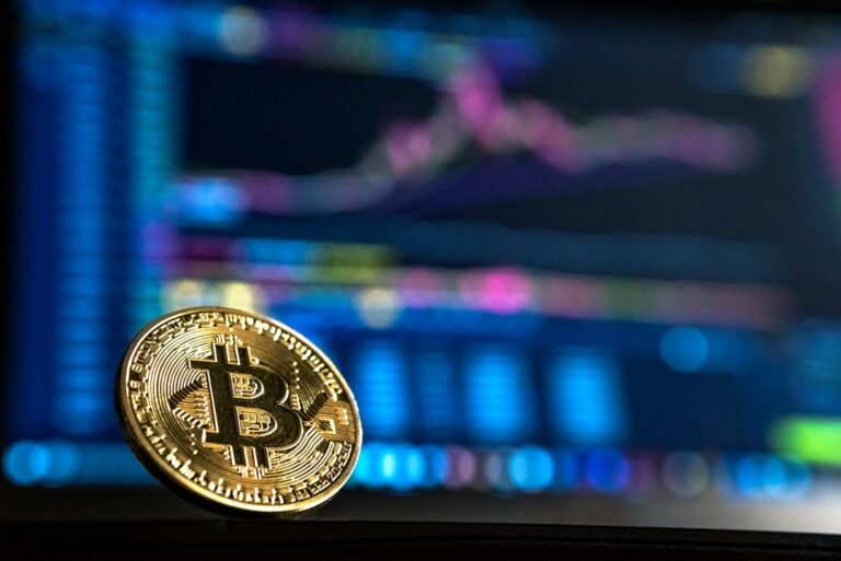 Биткойн монета на фона на графика с пазарни котировки
